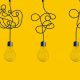 Hanging light bulbs on yellow background