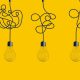 Hanging light bulbs on yellow background