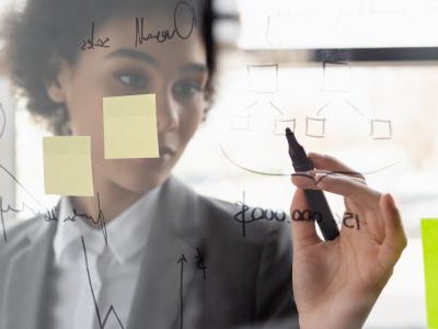 Woman drawing on board with sticky notes